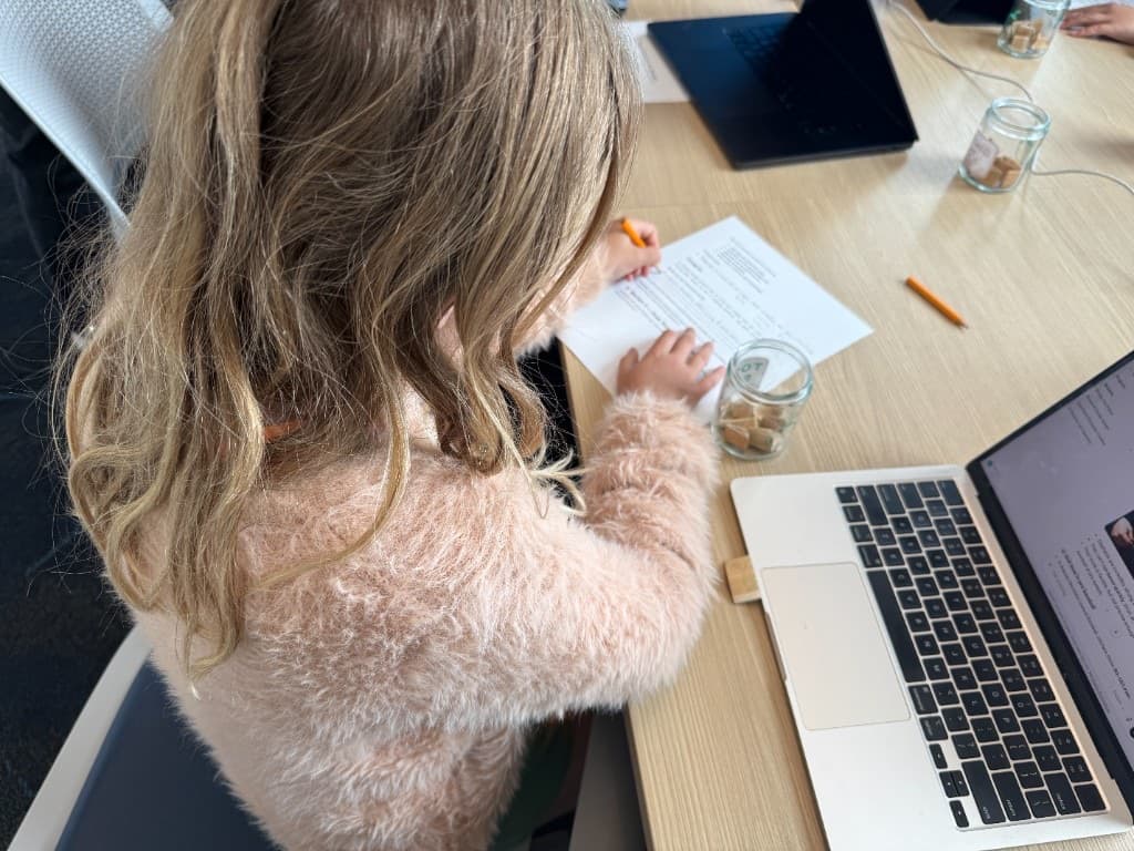 Instructor helping a student build a character on a laptop