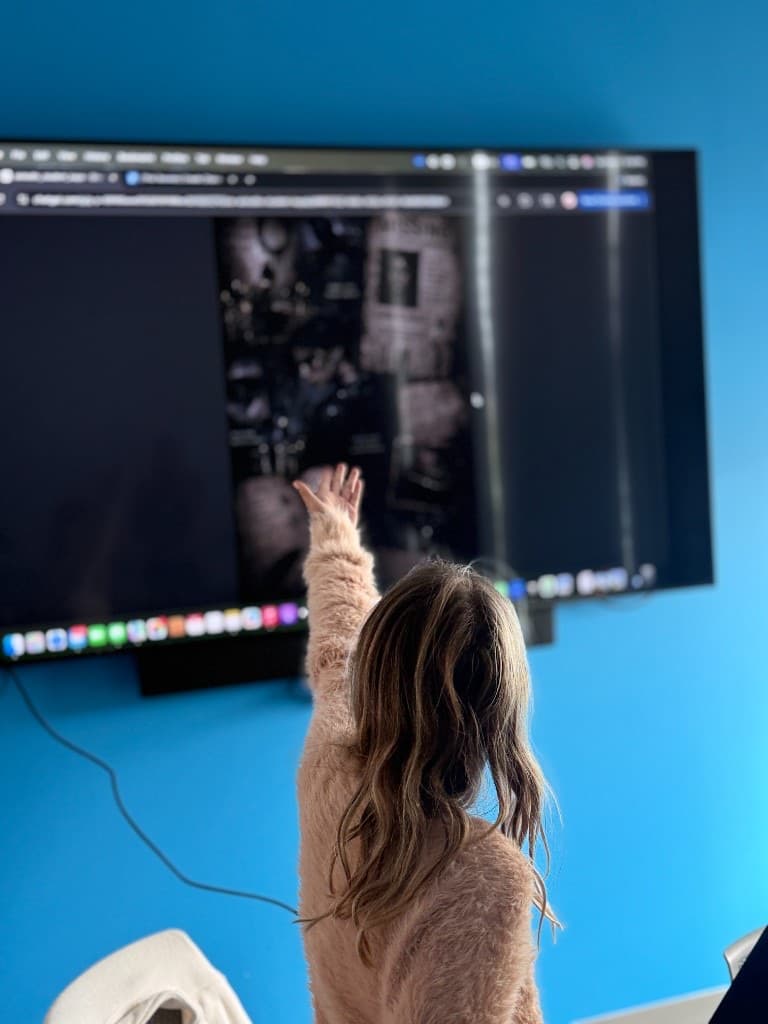 Student pointing to their story illustration on the big screen