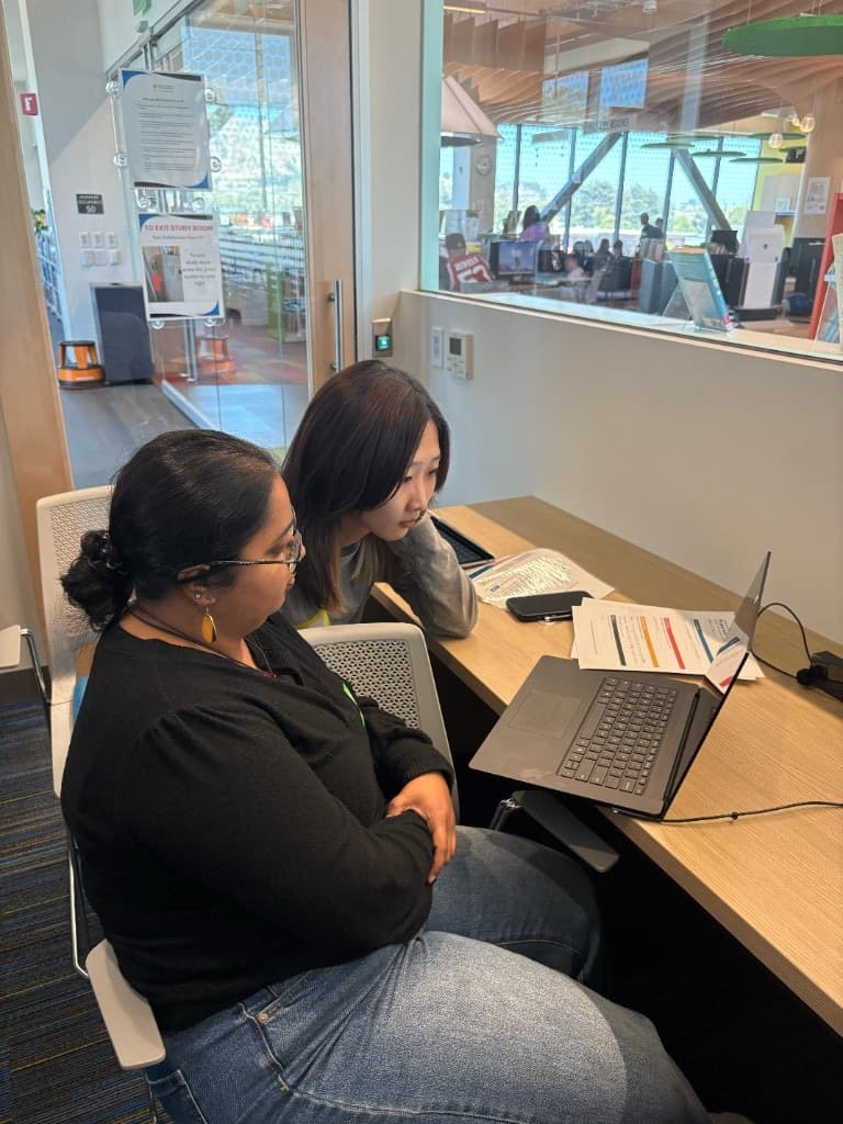 Mentor and student reviewing a project together on a laptop